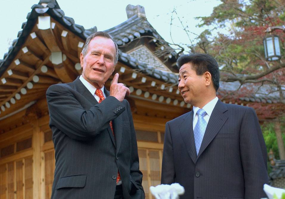 Former U.S. President George H. Bush talks with South Korean President Moo-Hyun