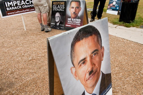A picture of President Barack Obama with a Hitler-like mustache is seen at a stand of controversial politician Lyndon LaRouche's movement during a march of supporters.