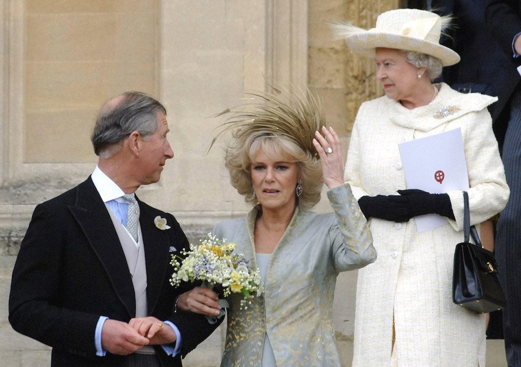 Prince Charles and Camila Parker Bowles walking in front of the queen. 