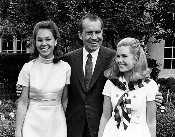 Le président Richard Nixon rit avec ses filles, Julie (à gauche) et Tricia.