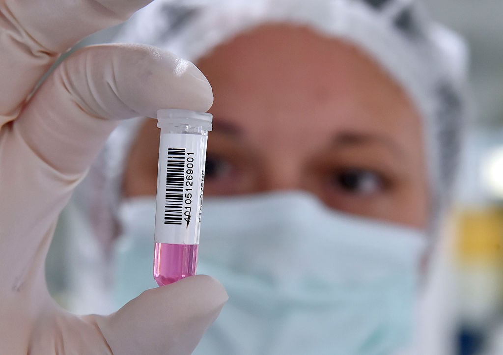 A lab technician handles a sample of DNA A lab technician handles a sample of DNA