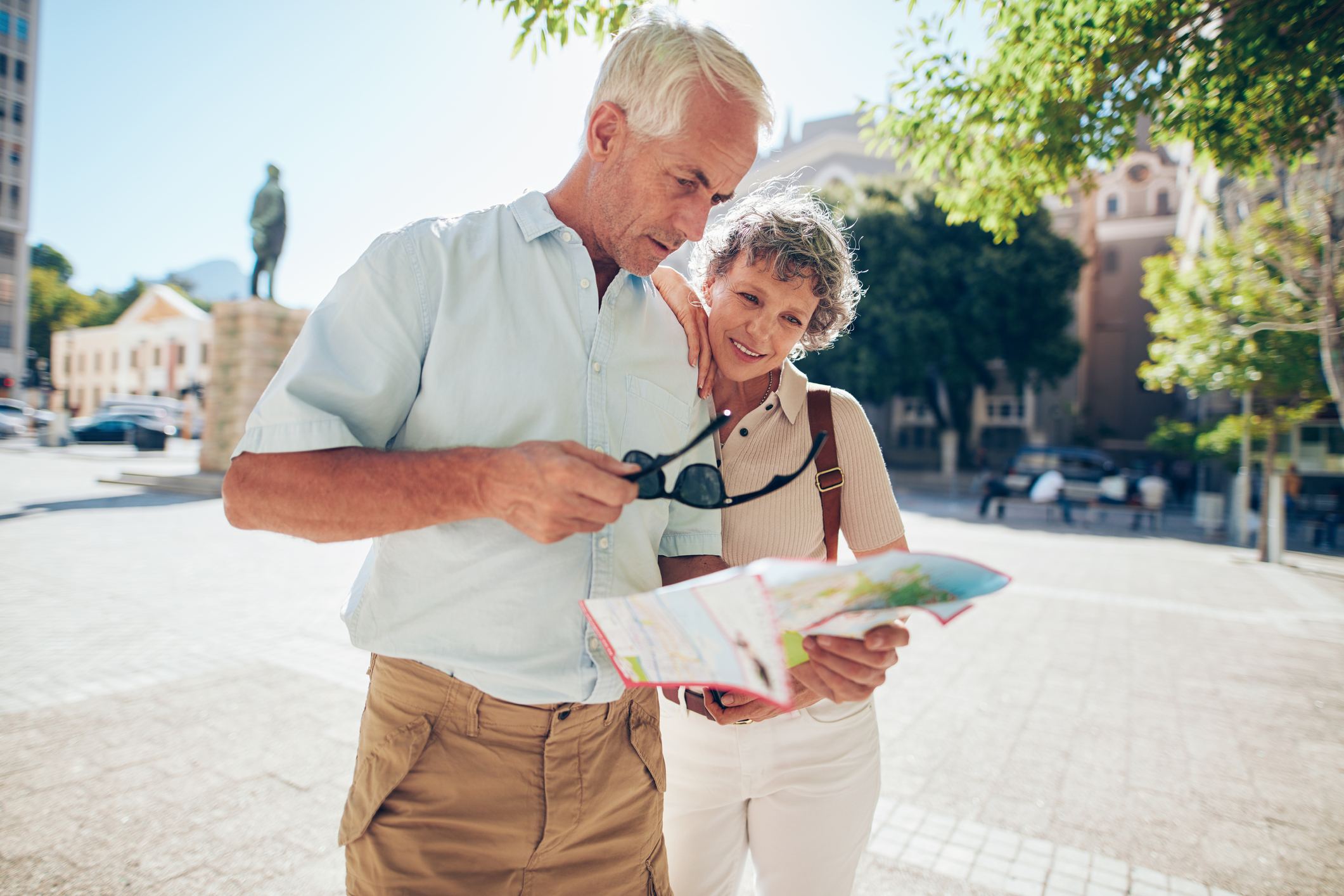 senior couple reading a map while traveling