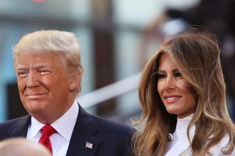 Republican presidential candidate Donald Trump sits with his wife Melania Trump