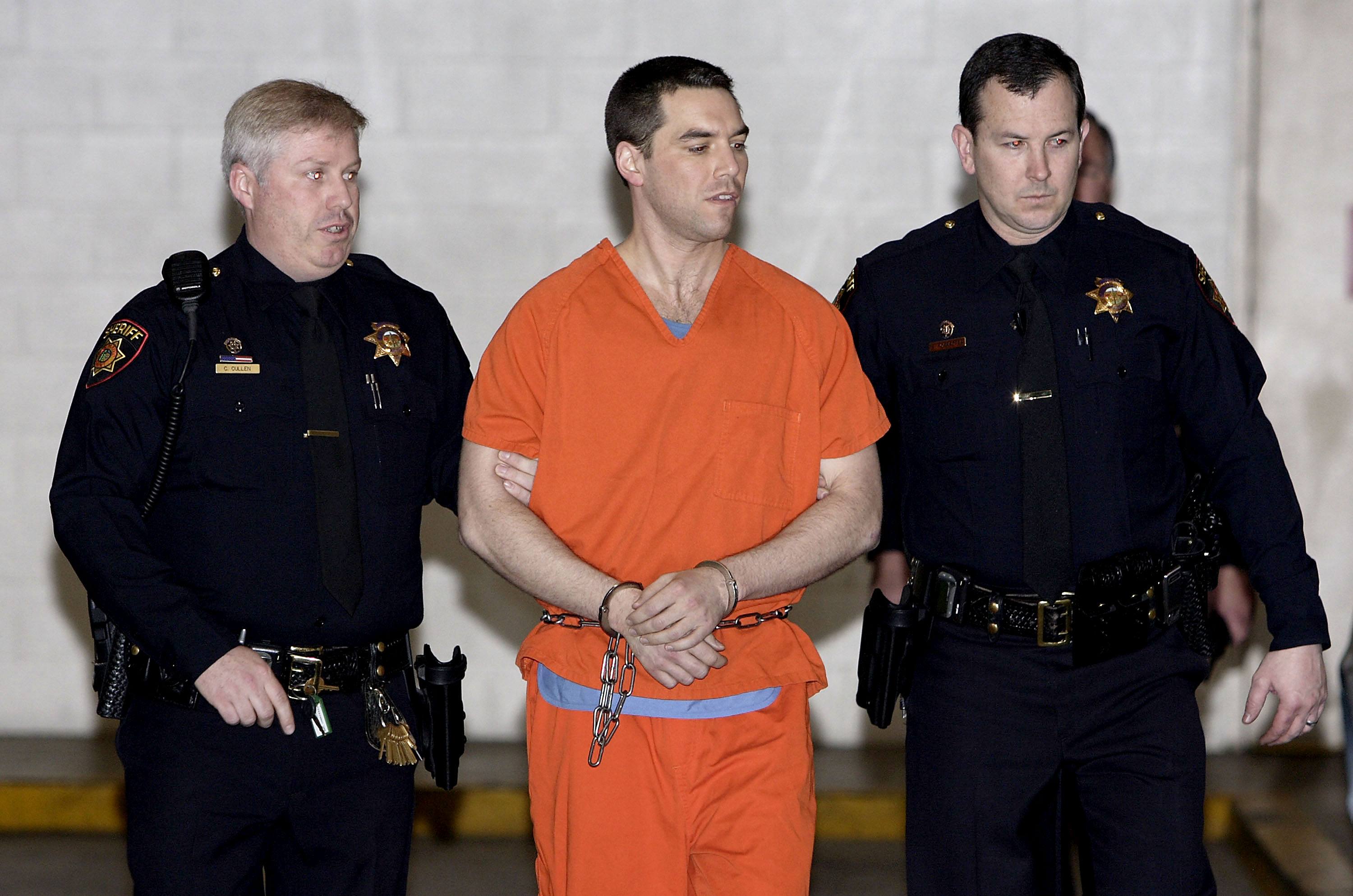 Convicted murderer Scott Peterson is escorted by two San Mateo County Sheriff deputies as he is walked from the jail to an awaiting van.