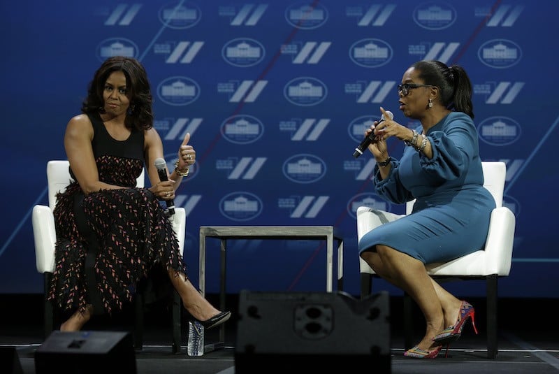 US First lady Michelle Obama (L) gestures next to Oprah Winfrey on a stage at the White House Summit on the United State of Women in Washington, DC on June 14, 2016.