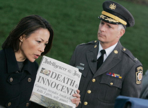 Reporter Ann Curry (R) holds a newspaper with the headline reading "Death of Innocents" while she interviews Pennsylvania State Police Col. Jeffrey Miller (R) near the scene of the shooting at a one room Amish schoolhouse October 3, 2006 in Nickel Mines, Pennsylvania. Officials said a milk truck driver identified as Charles Carl Roberts IV entered the schoolhouse, let the boys and adults go free, tied up the girls and shot them execution style before committing suicide. Five girls are dead and at least seven others injured. ann curry with a newspaper