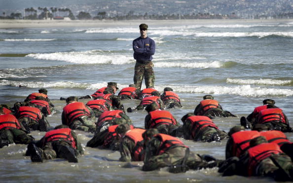 During a Hell Week surf drill evolution, a Navy SEAL instructor assists students from Basic Underwater Demolition class 245 with learning the importance of listening. |