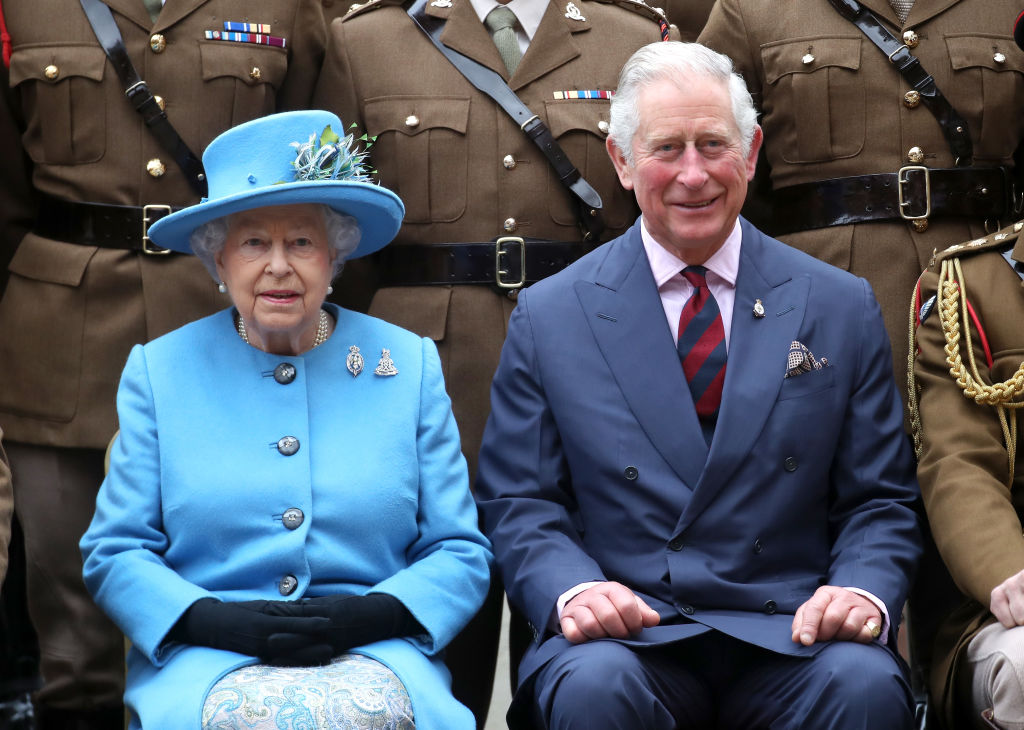 Queen Elizabeth II and Prince Charles sitting next to each other.
