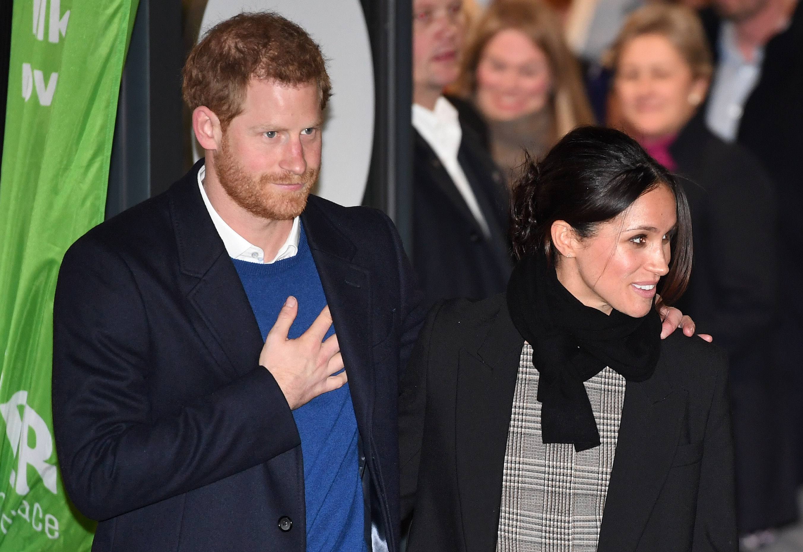 Prince Harry (L) and fiancee Meghan Markle leave after their visit to Star Hub