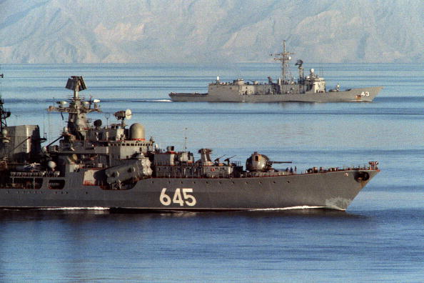 A Soviet warship passes alongside the U.S. guided missile frigate USS Thach