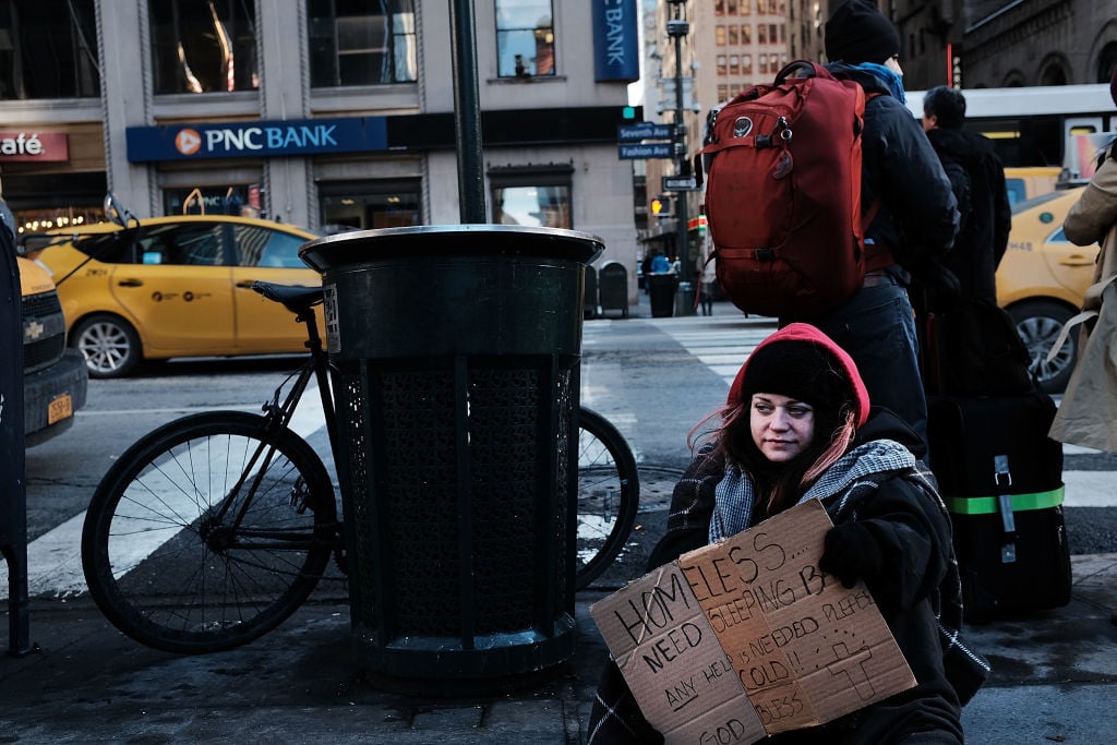 A young homeless woman panhandles on the streets of Manhattan