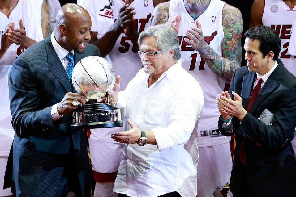 Former Miami Heat player Alonzo Mourning presents the Eastern Conference Championship trophy to team owner Micky Arison
