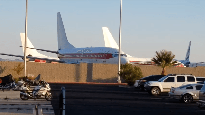 White plane with red stripe and no other markings parking lot