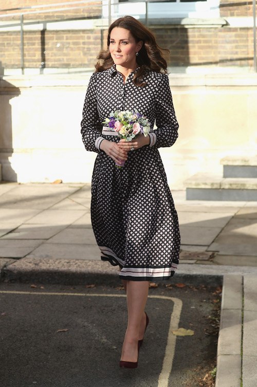 Kate Middleton walking with a bouquet in her hands. 