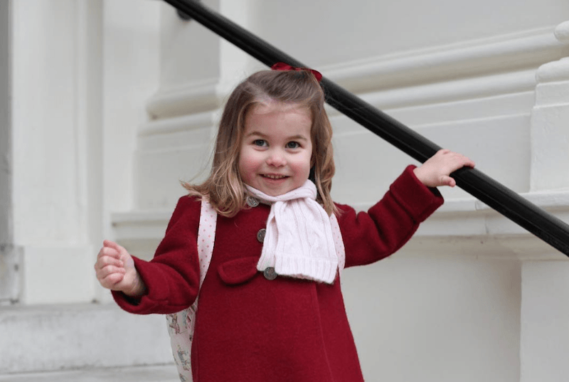 Princess Charlotte holds a railing as she climbs down a staircase. Princess Charlotte holds a railing as she climbs down a staircase.
