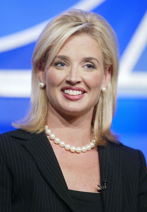 Laurie Dhue smiling while wearing a black top and white pearls. Laurie Dhue smiling while wearing a black top and white pearls.