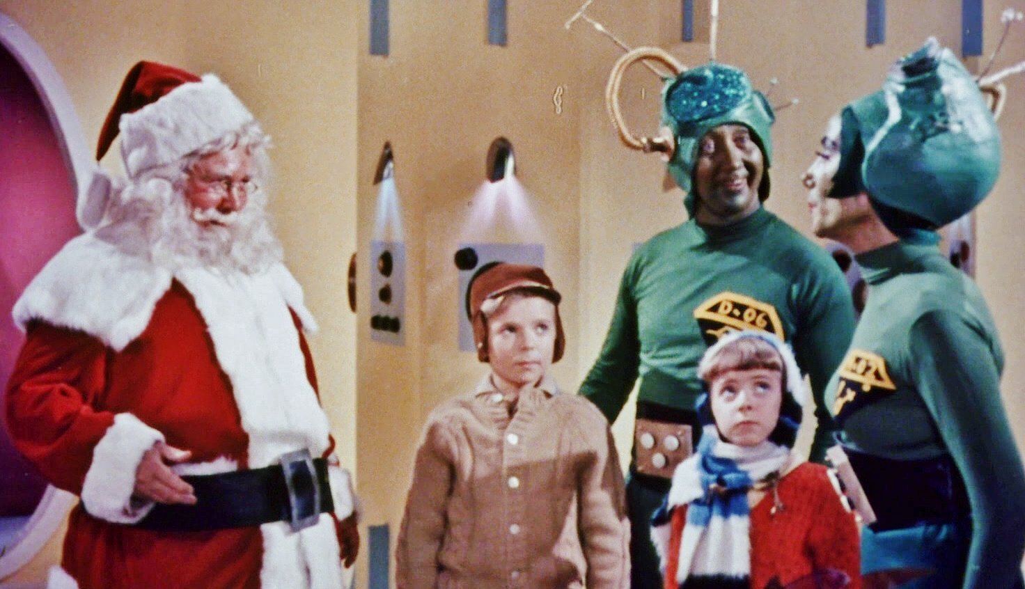 Santa talks to two people in martian outfits