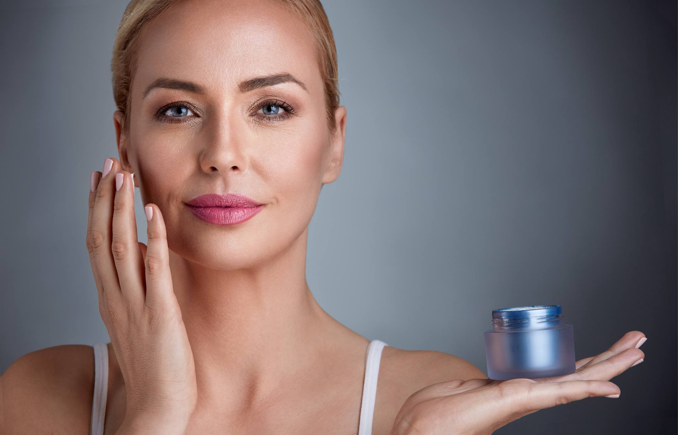 Woman applying moisturizing cream to her skin