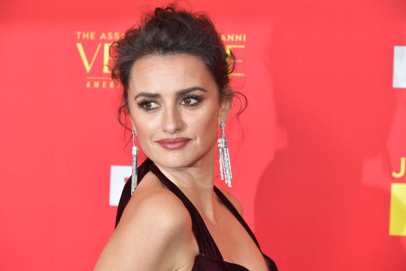 Penelope Cruz posing on a red carpet in a black dress and silver earrings. Penelope Cruz posing on a red carpet in a black dress and silver earrings.