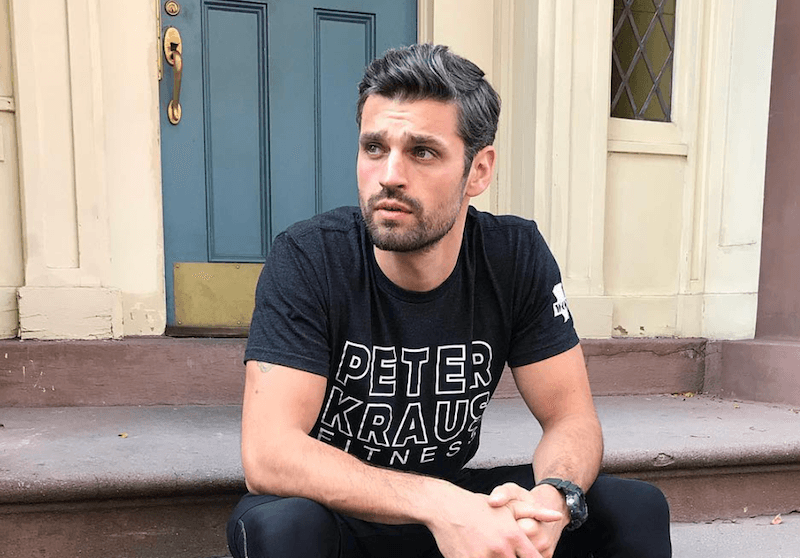 Peter sits on steps in front of a building. 