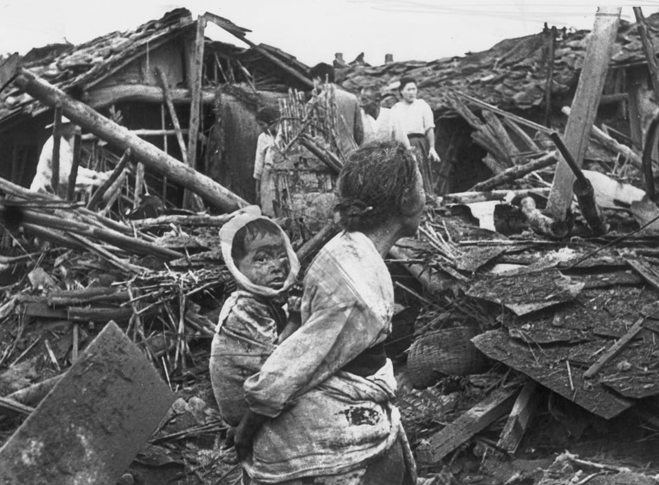 Pyongyang Falls An elderly woman and her grandchild wander among the debris of their wrecked home in the aftermath of an air raid by U.S. planes