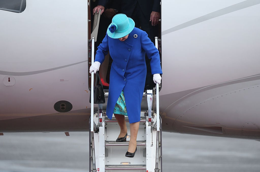 Queen Elizabeth II walks down the stairs of her plane upon her arrival with Prince Philip, the Duke of Edinburgh, at Tegel airport
