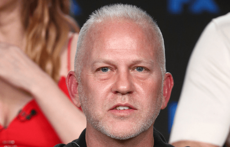 Ryan Murphy sitting on stage during a panel presentation. 