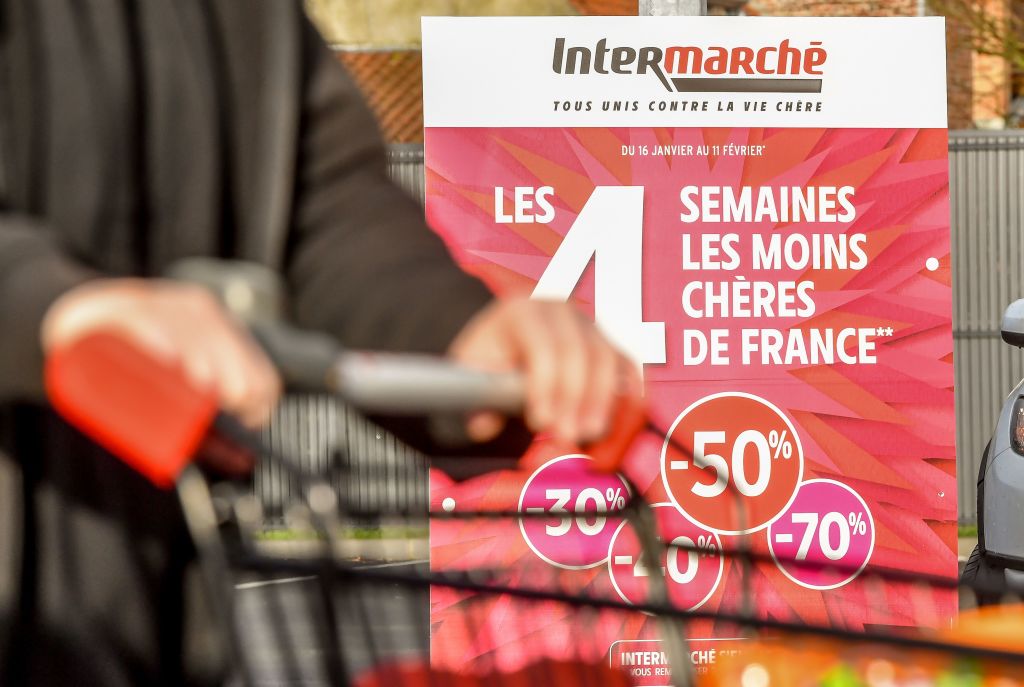 Woman walks past sale sign at Intermarche supermarket