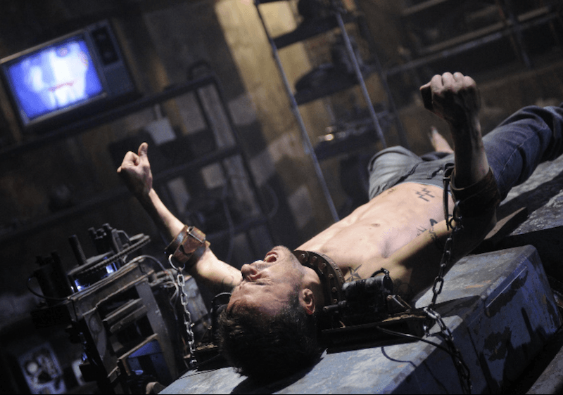 A man is trapped on a table and tied with chains. A man is trapped on a table and tied with chains.