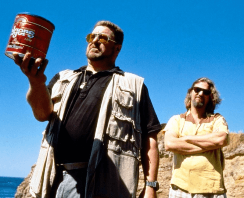 A man holds up a coffee can. A man holds up a coffee can.