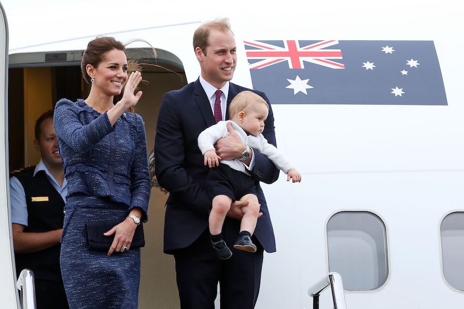 Catherine, Duchess of Cambridge, Prince William, Duke of Cambridge and Prince George of Cambridge wave to the crowd before boarding a Royal Australian Air Force plane