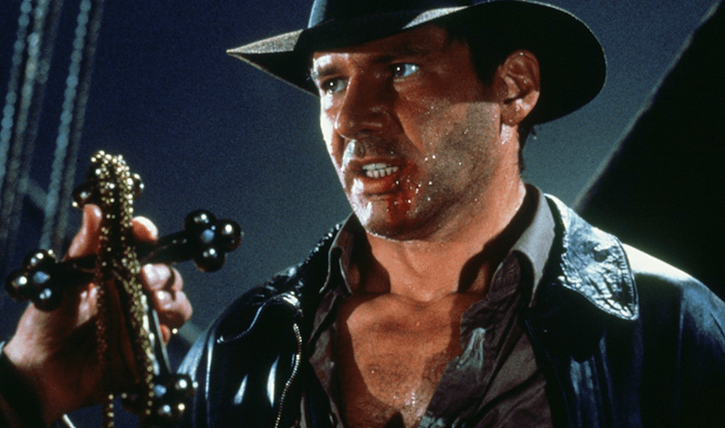 Indiana Jones holding up a black cross. Indiana Jones holding up a black cross.