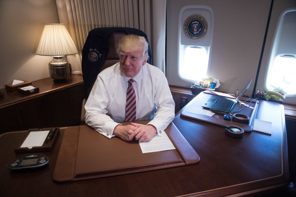 US President Donald Trump poses in his office aboard Air Force One