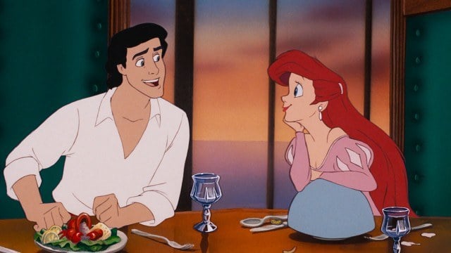 Ariel looks at Prince Eric with stuffed crab on his plate in The Little Mermaid