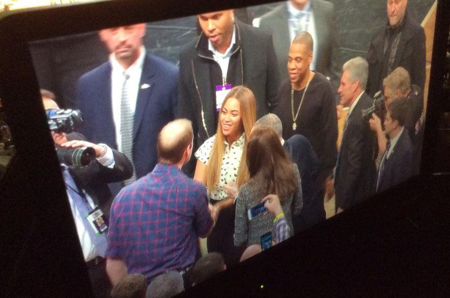 A monitor showing Beyoncé and JAY-Z shaking hands with Prince William and Kate Middleton