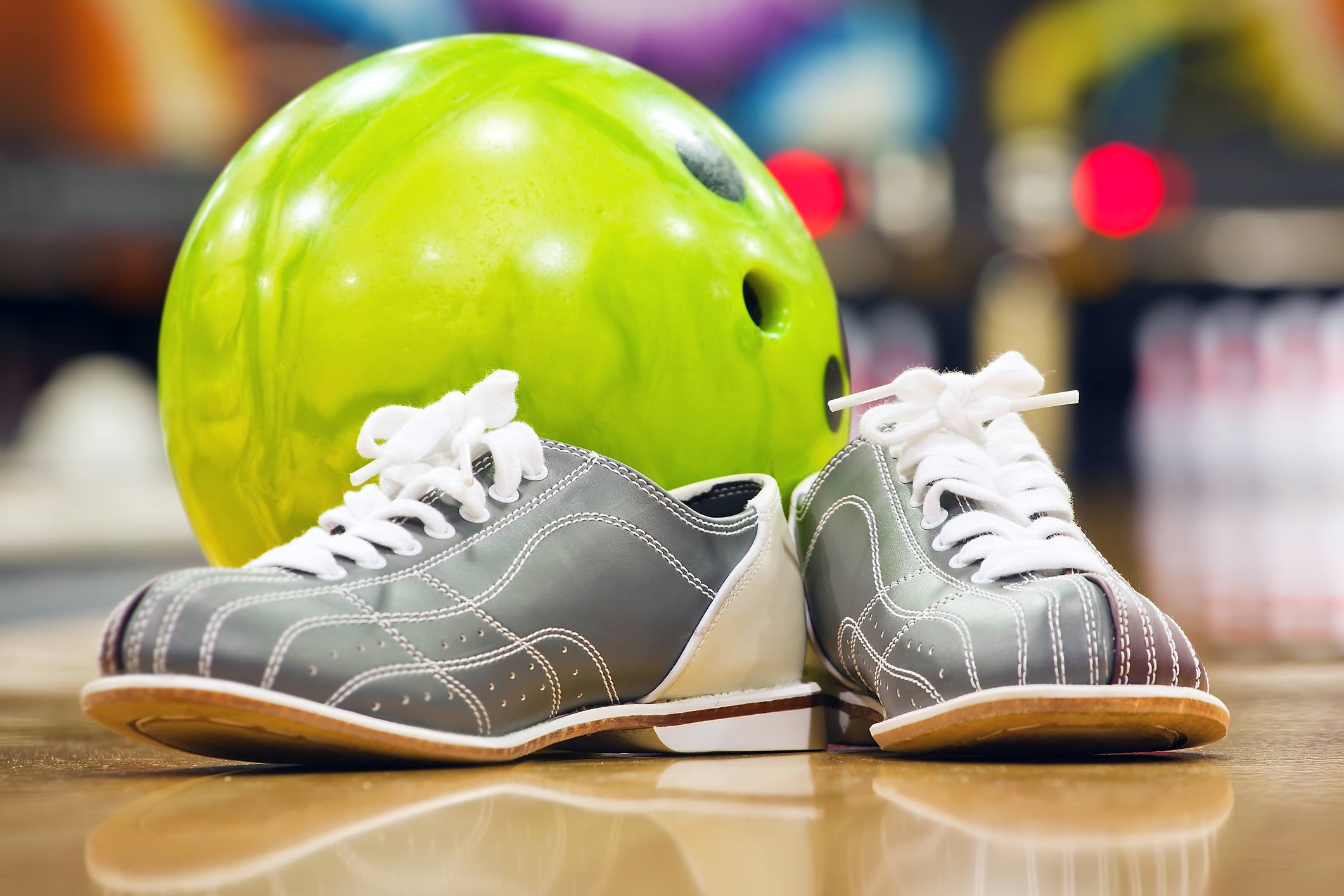 Close-up of bowling shoes and neon green ball 
