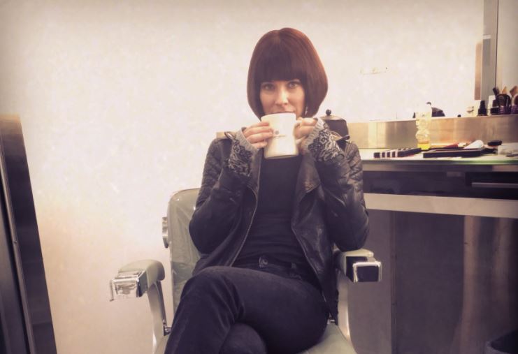 Evangeline Lilly sitting in a chair holding a mug. Evangeline Lilly sitting in a chair holding a mug.