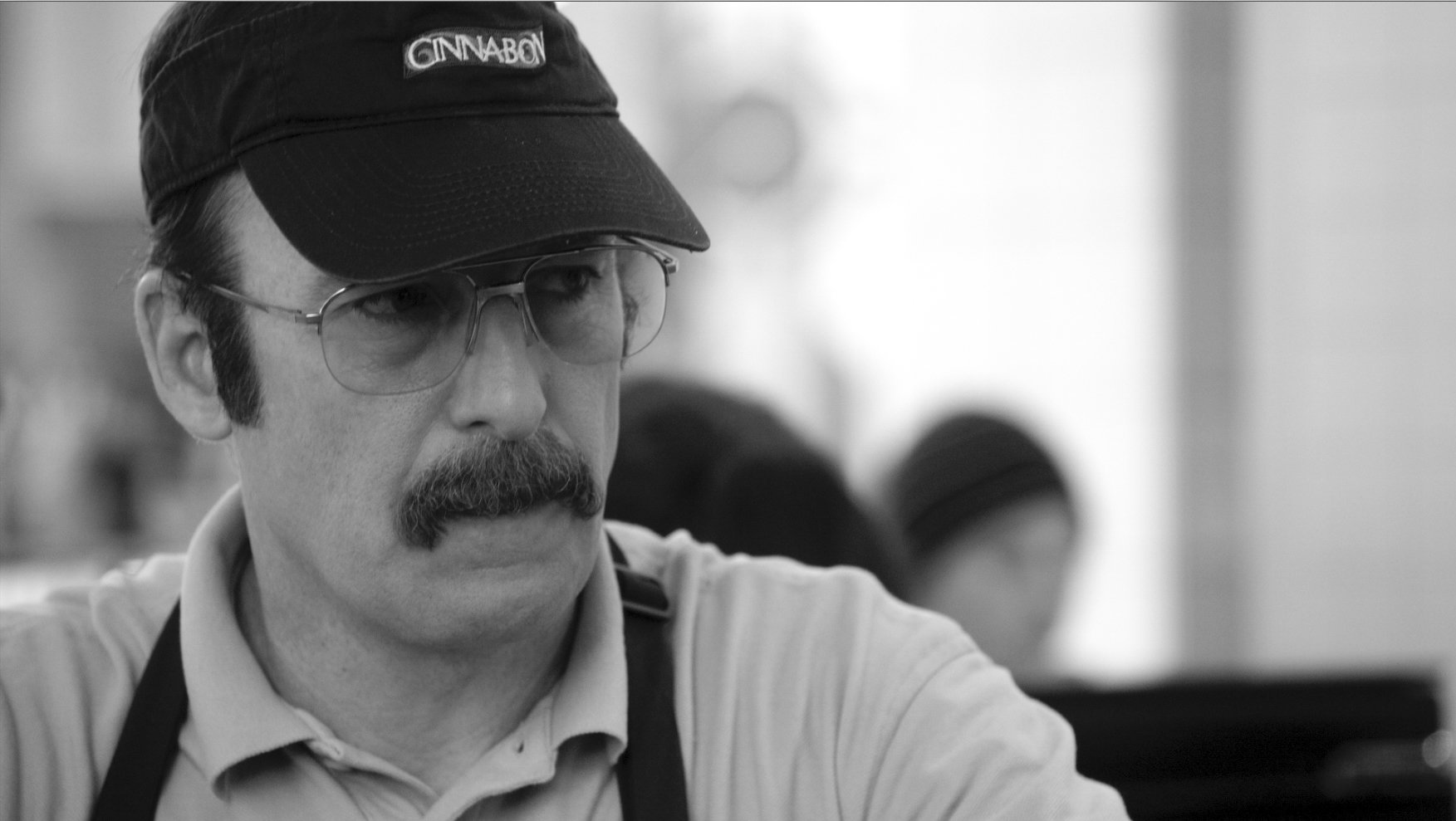 Gene smiles while staring straight ahead. Bob Odenkirk as Gene on Better Call Saul.