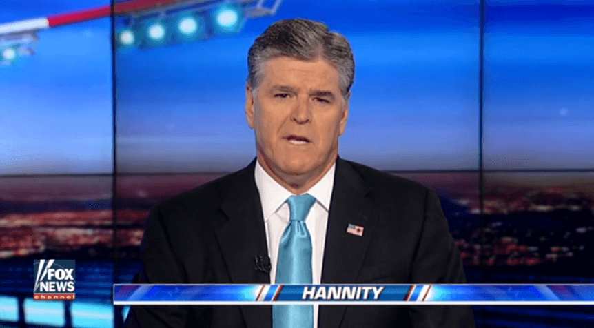 Sean Hannity looks into the camera while wearing a suit and blue tie