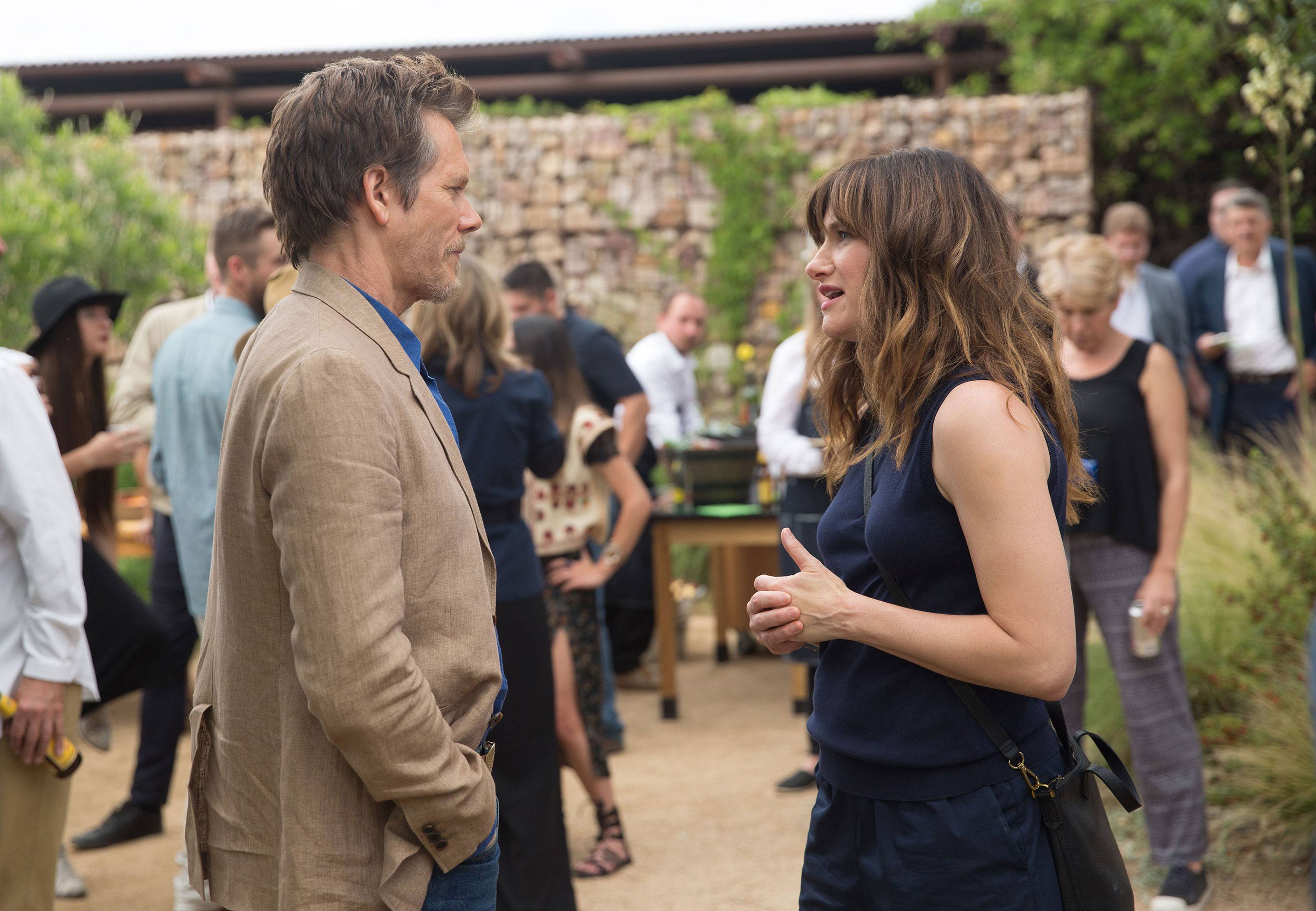 Kathryn Hahn and Kevin Bacon stand and look at each other