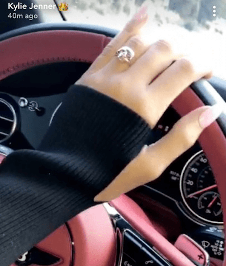 Kylie Jenner's hand on a pink steering wheel