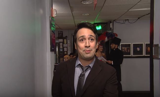 A chorus girl and Abraham Lincoln in a top hat can be seen in the background behind Lin-Manuel Miranda during his opening monologue song. A chorus girl and Abraham Lincoln in a top hat can be seen in the background behind Lin-Manuel Miranda during his opening monologue song.