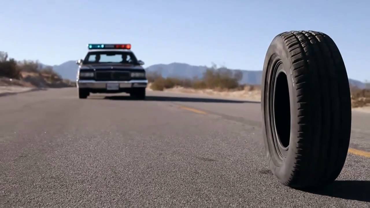 a rubber tire on a road behind a cop car
