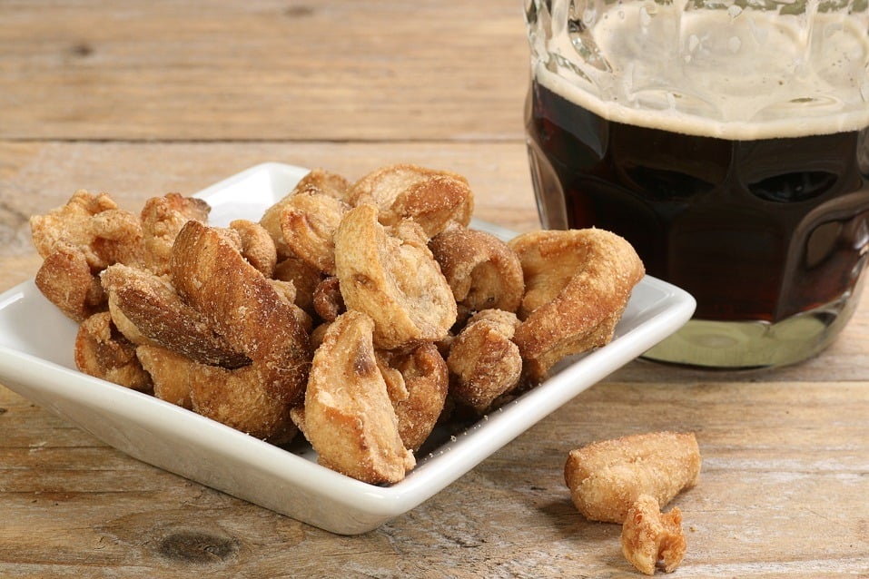 Traditional english midland snack of salted pork scratchings with a pint of beer
