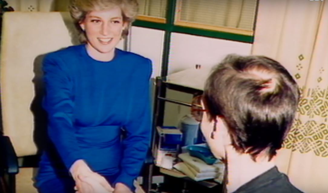 Princess Diana sitting on a beige sofa while greeting another person. Princess Diana sitting on a beige sofa while greeting another person.