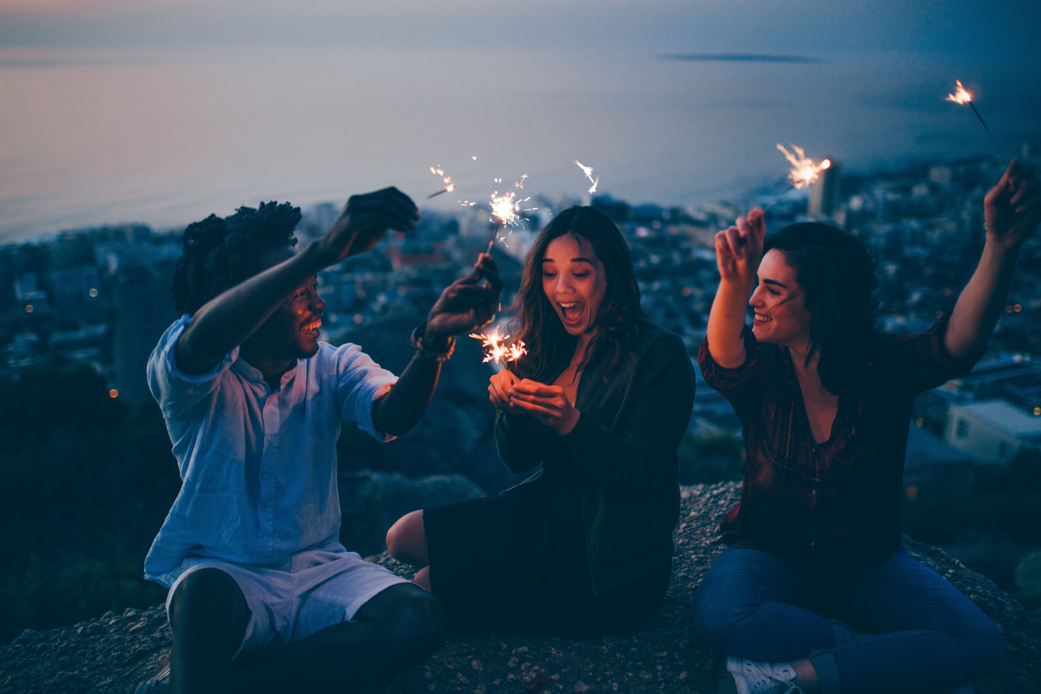 Group of friends celebrating with sparklers at night