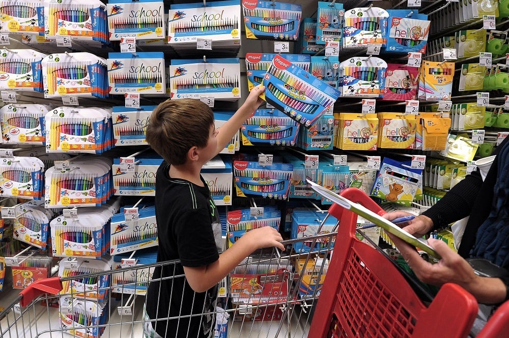 A boy holds pencils at a supermarket of Strasbourg