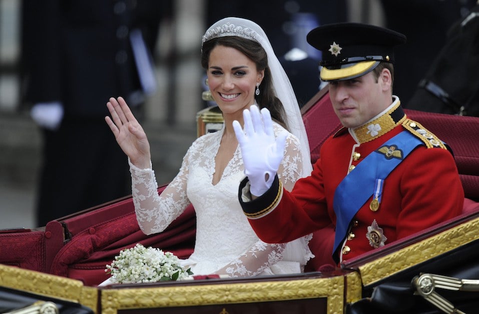 Britain's Prince William and his wife Kate, Duchess of Cambridge, wave as they travel in the 1902 State Landau carriage