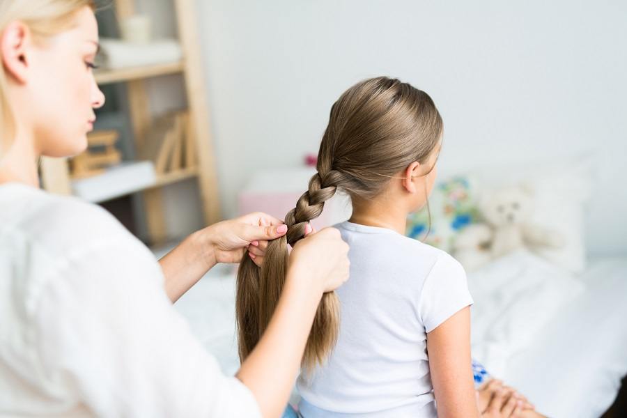 woman braiding her daughters woman braiding her daughters