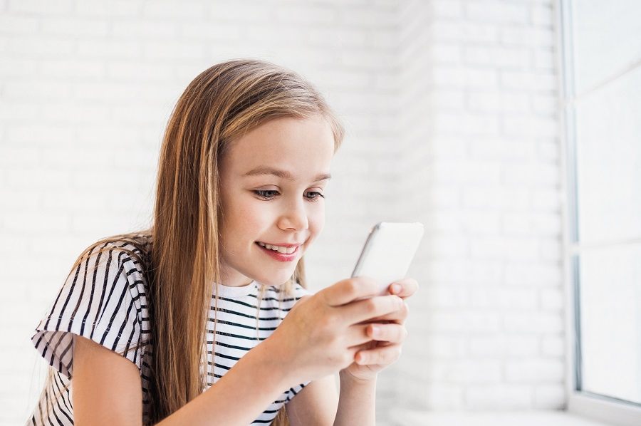 Happy little girl holding smart phone Happy little girl holding smart phone